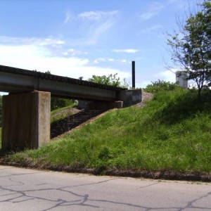 Bryan Street trestle looking southeast. The smoke stack and tower are of the now closed Bartlett Collins glass plant.