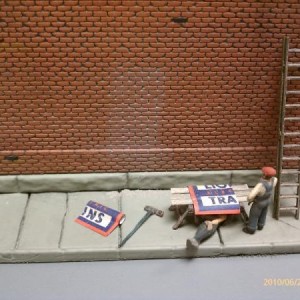 Leonard's far side - workers putting up another sign.  Can you tell what the sign will advertise?