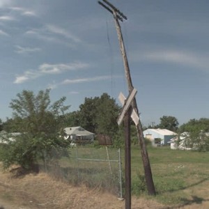 Old telegraph pole at Rhodes Ave crossing facing south.